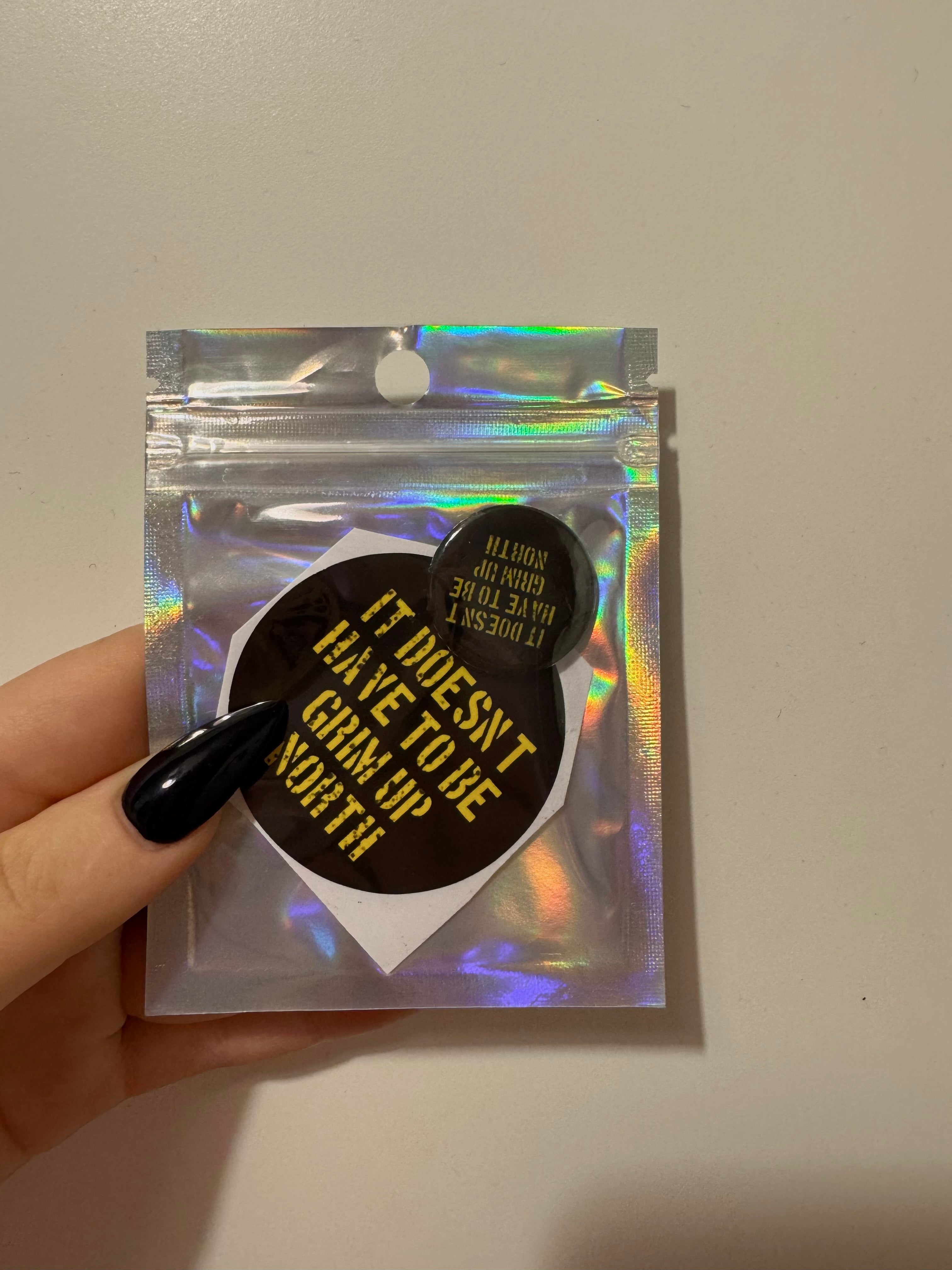 'it doesn't have to be grim up north' badge & sticker pack